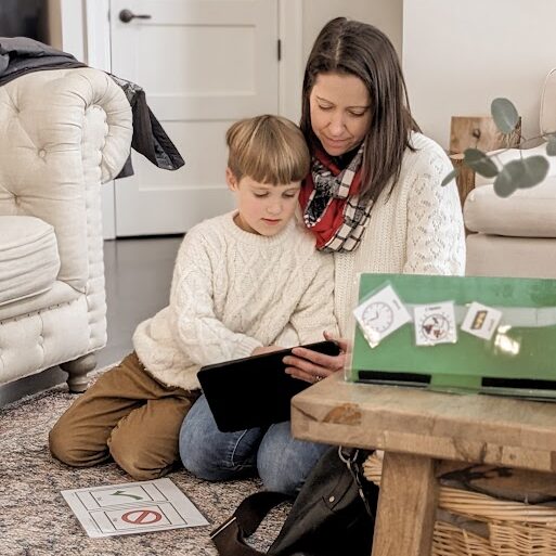 child sitting with adult working on touch pad